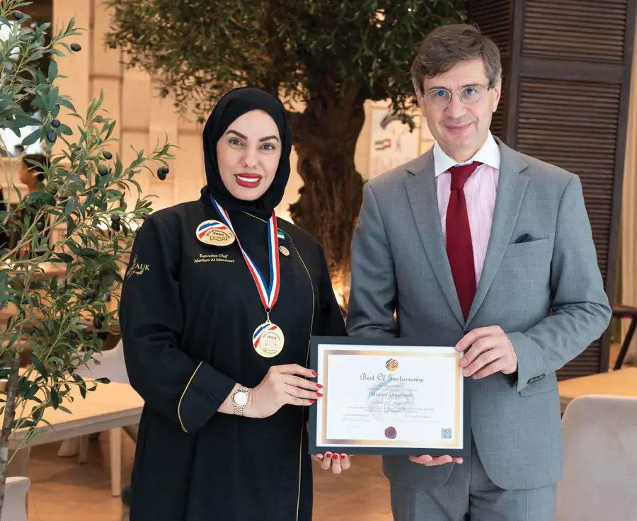 Chef Mariam Al Mansoori receiving her certificate from the French Ambassador to the UAE