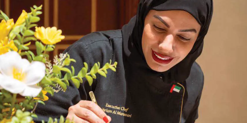 Chef Mariam Al Mansoori finishing a tray of fruit tarts
