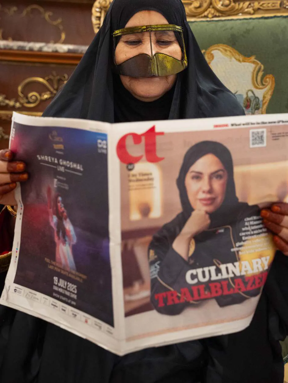 Chef Mariam Al Mansoori holding the City Times front page that names her a culinary trailblazer